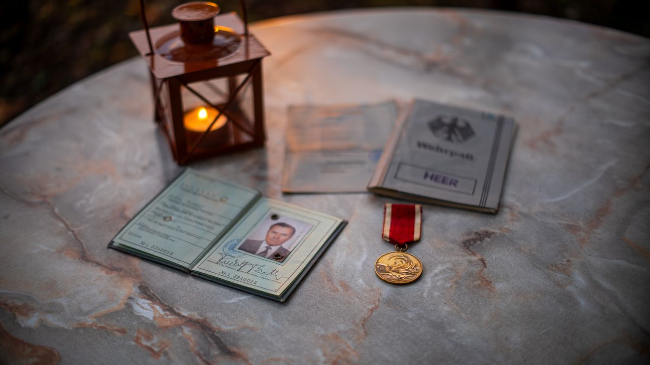 About A collection of vintage military memorabilia with a glowing lantern on a stone table.